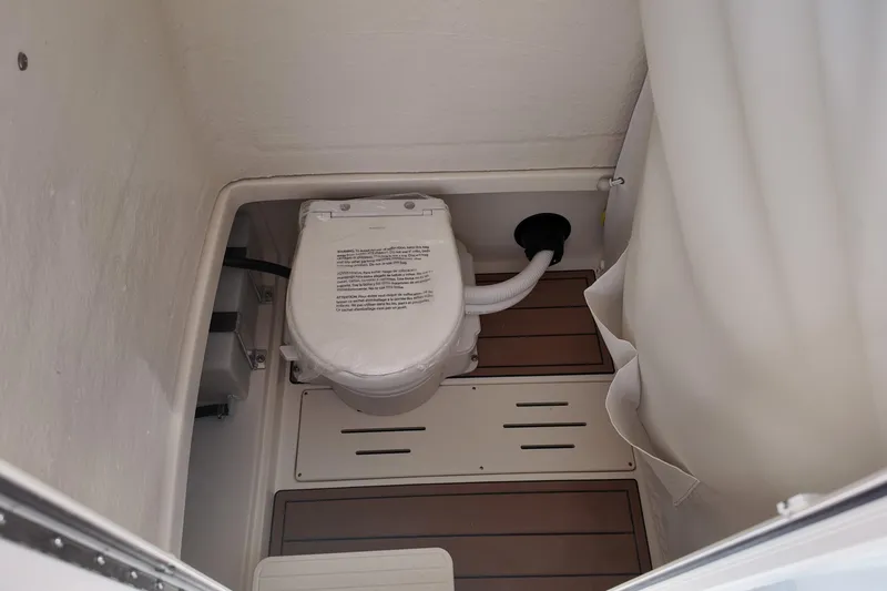 Slide: The Image of Interior of 2026 Bulls Bay 255 Center Console boat featuring a compact marine toilet. - 8