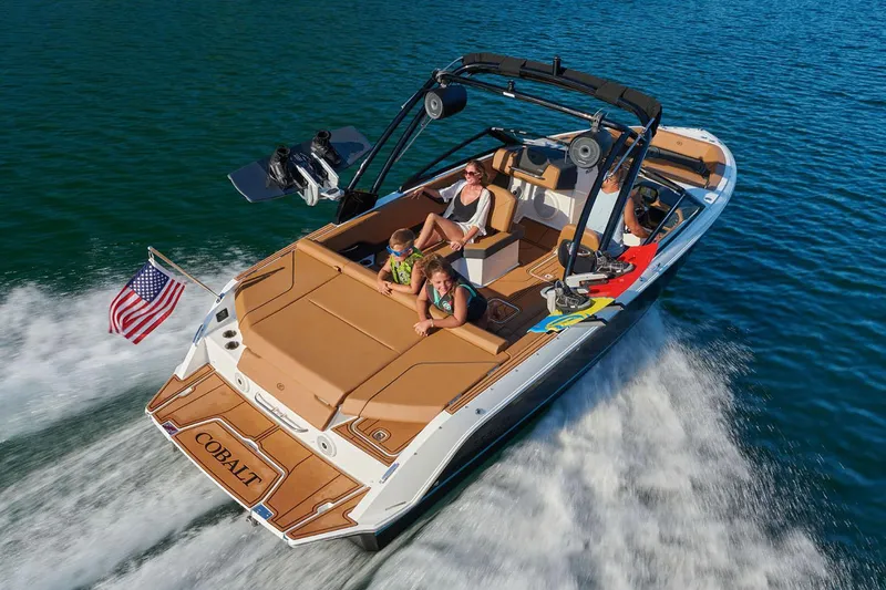 Slide: The Image of Manufacturer Provided Image: 2025 Cobalt CS23 boat cruising with passengers on a sunny day, American flag waving. - 7
