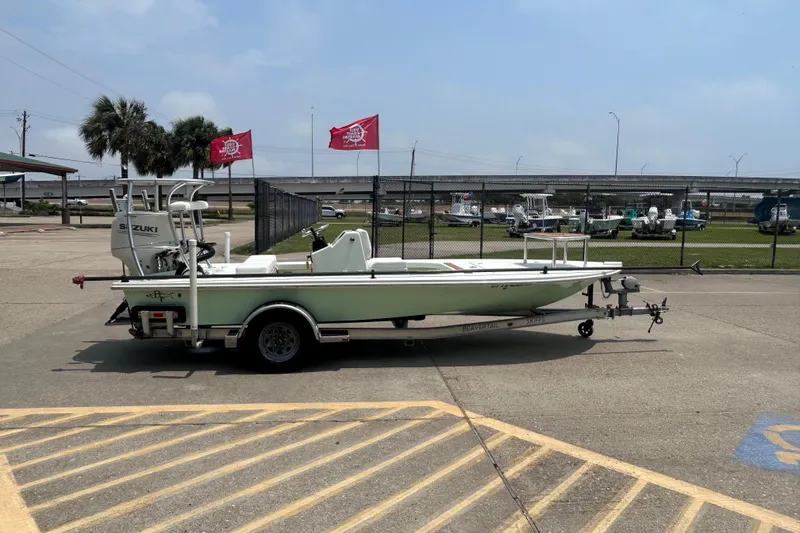 Slide: The Image of 2019 Beavertail Skiffs Mosquito boat on trailer in parking lot, clear sky background. - 2