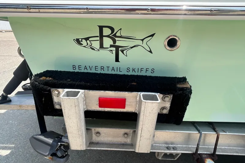 Slide: The Image of 2019 Beavertail Skiffs Mosquito boat logo on light green hull, trailer visible. - 6