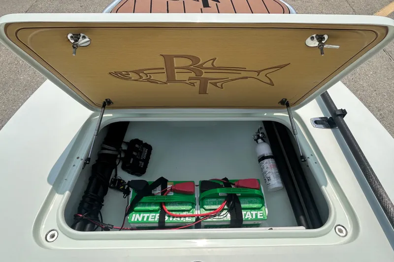 Slide: The Image of Open storage compartment of 2019 Beavertail Skiffs Mosquito with battery and fire extinguisher. - 9