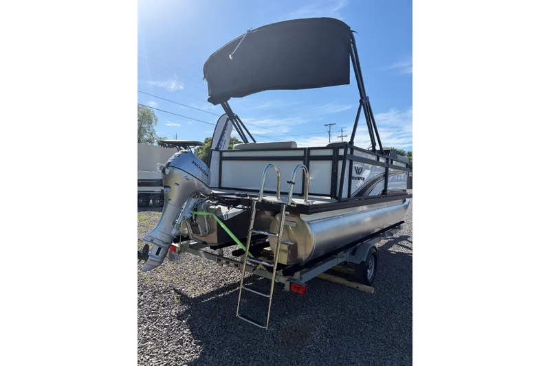 Slide: The Image of Pontoon boat Whisper S17 2026 with outboard motor and canopy on gravel. - 7