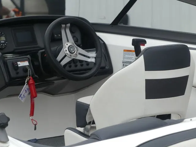 Slide: The Image of Interior of a 2019 Yamaha AR195 boat with steering wheel and seat. - 12
