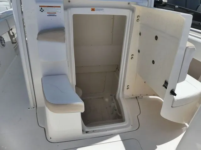 Slide: The Image of Open storage compartment on a 2018 Robalo R302 Center Console boat. - 17