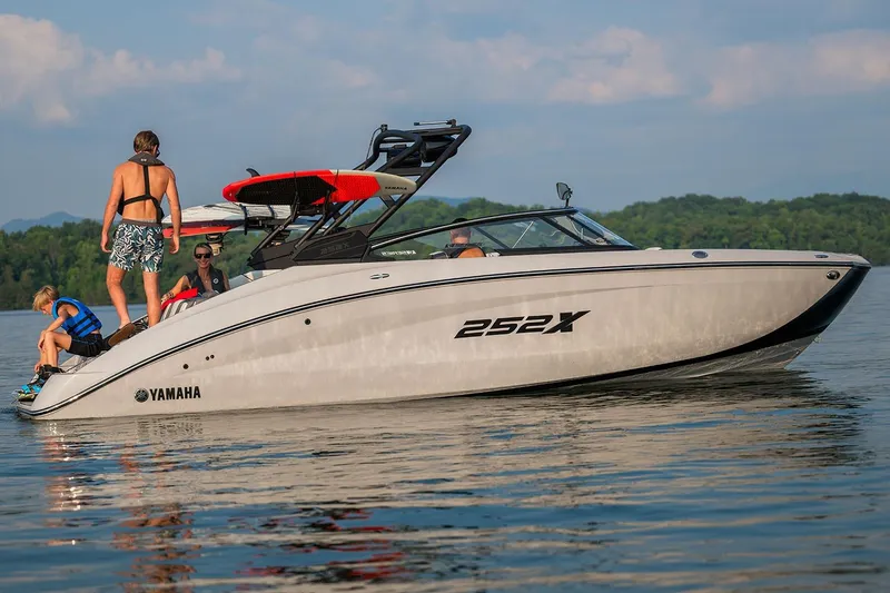 Slide: The Image of Manufacturer Provided Image: 2026 Yamaha Boats 252XE on a lake with people enjoying water activities. - 12