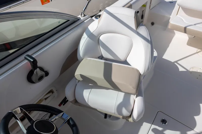 Slide: The Image of 2020 Robalo R227 Dual Console boat interior with white captain's chair and steering wheel. - 10
