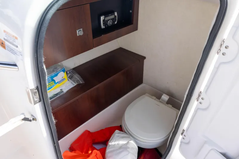 Slide: The Image of Interior of 2020 Robalo R227 Dual Console boat with compact marine toilet. - 13