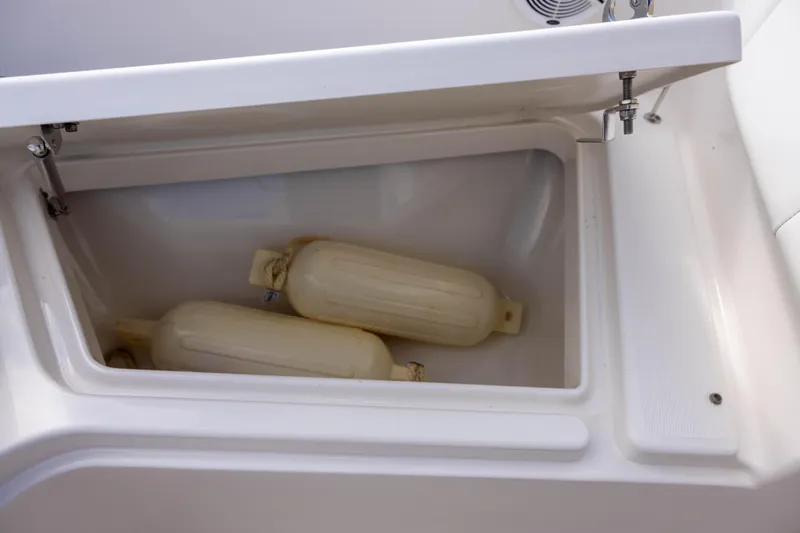 Slide: The Image of Storage compartment with fenders on a 2020 Robalo R227 Dual Console boat. - 17