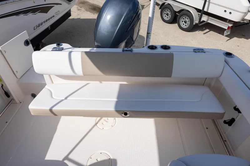 Slide: The Image of 2020 Robalo R227 Dual Console boat interior with seating and motor, parked on a trailer. - 7
