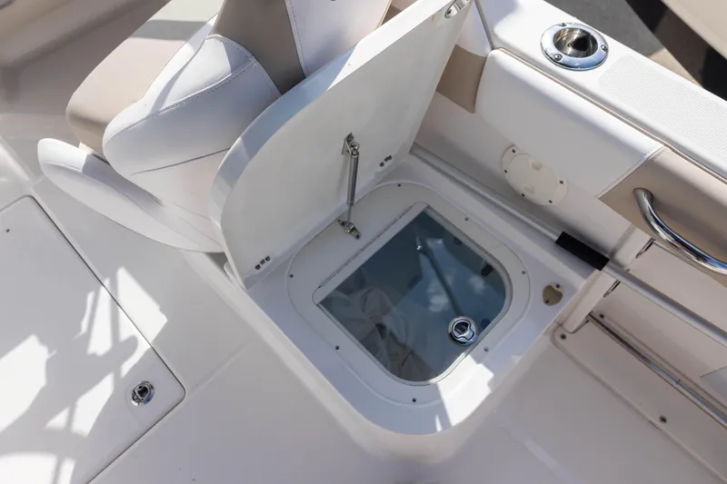 Slide: The Image of 2020 Robalo R227 Dual Console boat seat with storage compartment open. - 8