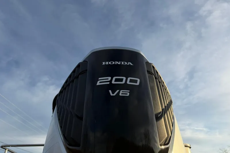 Slide: The Image of Outboard motor on Montego Bay ST8524 SB DLX 2026 boat under clear sky. - 11