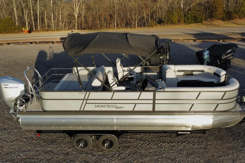 Slide: The Image of 2026 Montego Bay ST8524 SB DLX pontoon boat with canopy and Honda motor on trailer. - 4