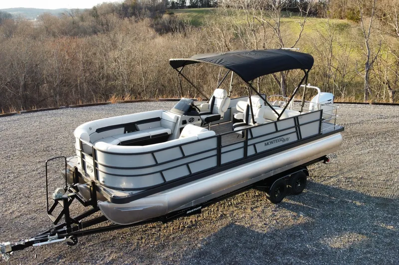 Slide: The Image of 2026 Montego Bay ST8524 SB DLX pontoon boat on trailer, parked in scenic outdoor setting. - 5