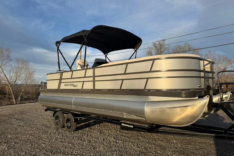 Slide: The Image of 2026 Montego Bay ST8524 SB DLX pontoon boat on trailer, under clear sky. - 7