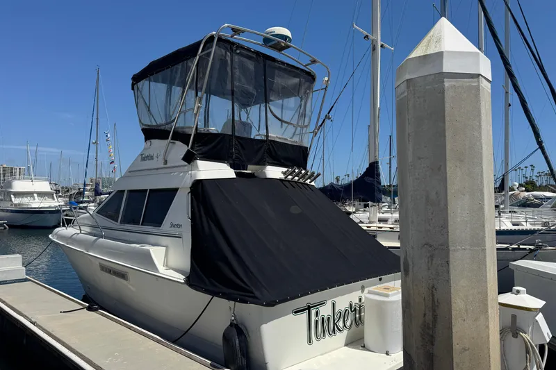 The Image of 1995 Silverton 31 Convertible boat docked at marina, featuring flybridge and covered deck. - 0