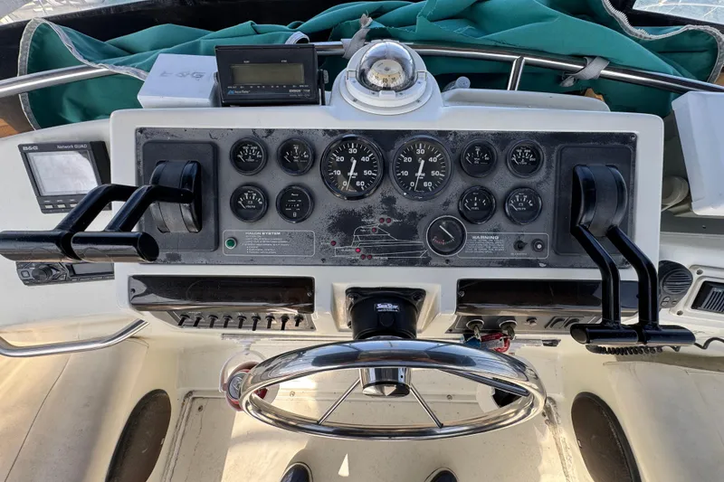 Slide: The Image of Control panel of a 1995 Silverton 31 Convertible boat with gauges and steering wheel. - 11