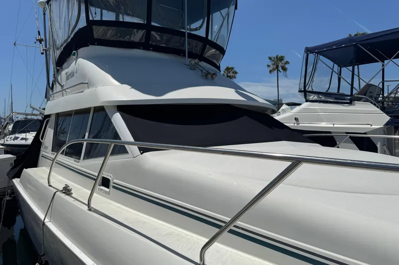 Slide: The Image of 1995 Silverton 31 Convertible yacht docked under clear blue sky. - 2