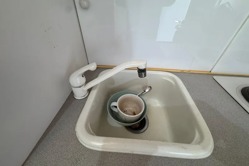 Slide: The Image of Small sink with dirty cups and spoon in a 1995 Silverton 31 Convertible boat. - 25