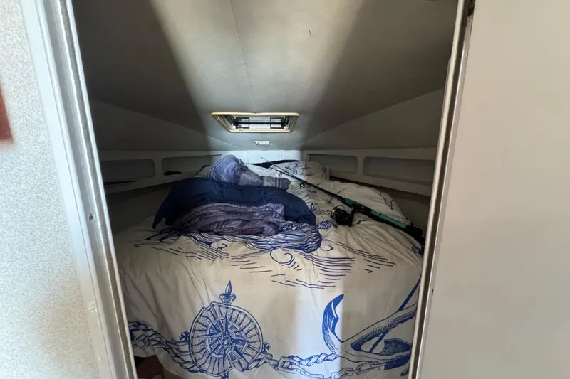 Slide: The Image of Cozy cabin interior of 1995 Silverton 31 Convertible with nautical-themed bedding. - 26