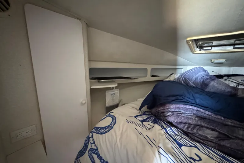 Slide: The Image of Interior cabin of a 1995 Silverton 31 Convertible boat with bedding and storage. - 28