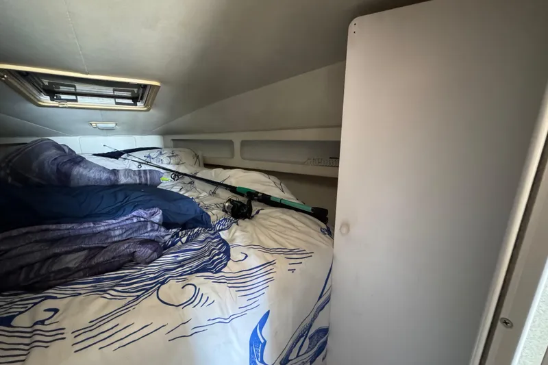 Slide: The Image of Cozy cabin interior of 1995 Silverton 31 Convertible with fishing rods and nautical bedding. - 29