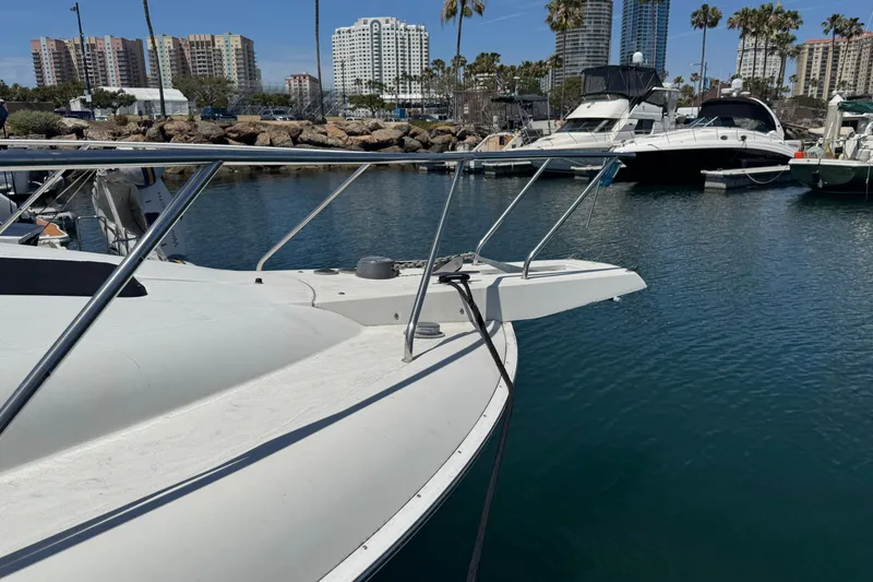 Slide: The Image of 1995 Silverton 31 Convertible yacht docked in a marina with city skyline. - 3