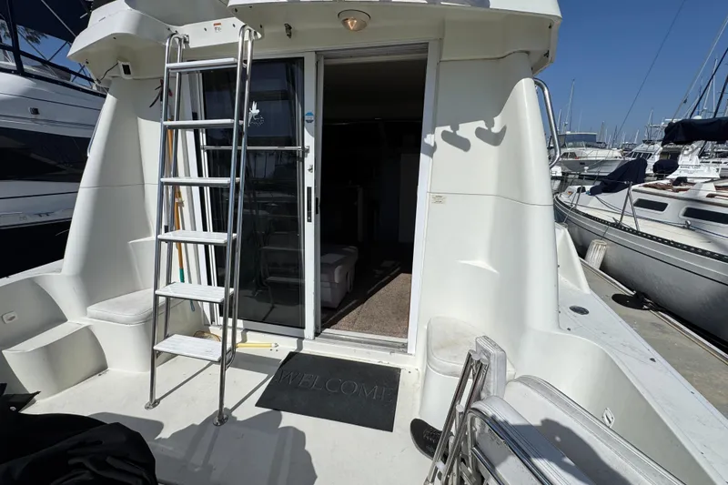 Slide: The Image of 1995 Silverton 31 Convertible yacht with ladder and open cabin door at marina. - 9