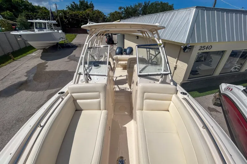 Slide: The Image of 2019 Grady-White Freedom 275 boat with spacious seating, docked near a building. - 12