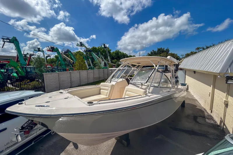 Slide: The Image of 2019 Grady-White Freedom 275 boat parked outdoors under a blue sky. - 14