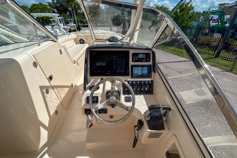 Slide: The Image of 2019 Grady-White Freedom 275 boat cockpit with steering wheel and control panel. - 7