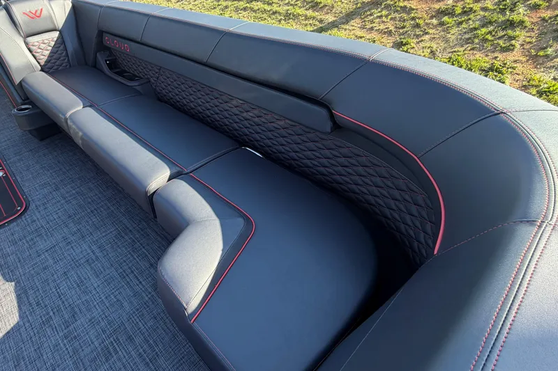 Slide: The Image of Luxurious seating on 2026 Whisper C25 Splash Pad boat, featuring sleek black upholstery with red accents. - 11