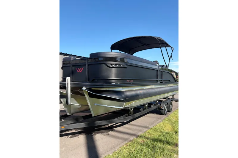 Slide: The Image of 2026 Whisper C25 Splash Pad pontoon boat on trailer, featuring sleek black design and canopy. - 16