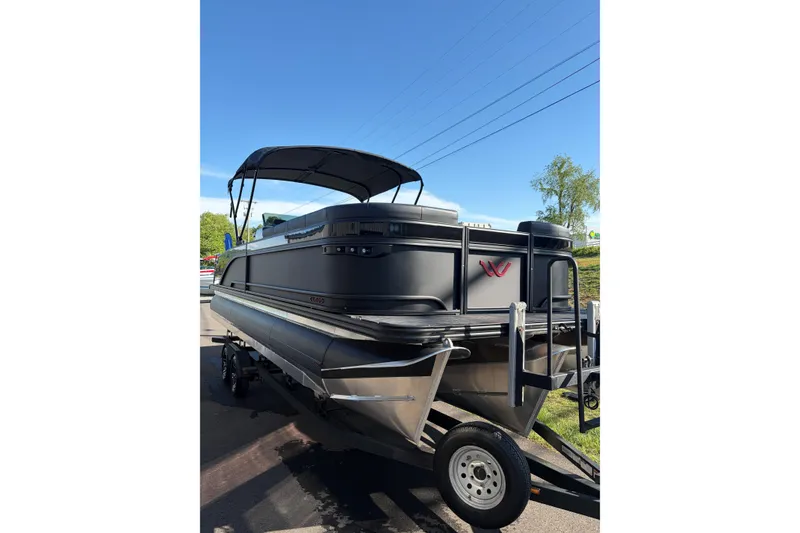 Slide: The Image of 2026 Whisper C25 Splash Pad pontoon boat on trailer under clear blue sky. - 20