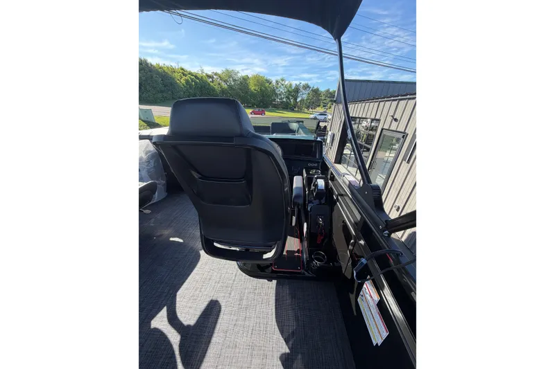 Slide: The Image of Interior view of 2026 Whisper C25 Splash Pad boat with black seating and modern controls. - 9
