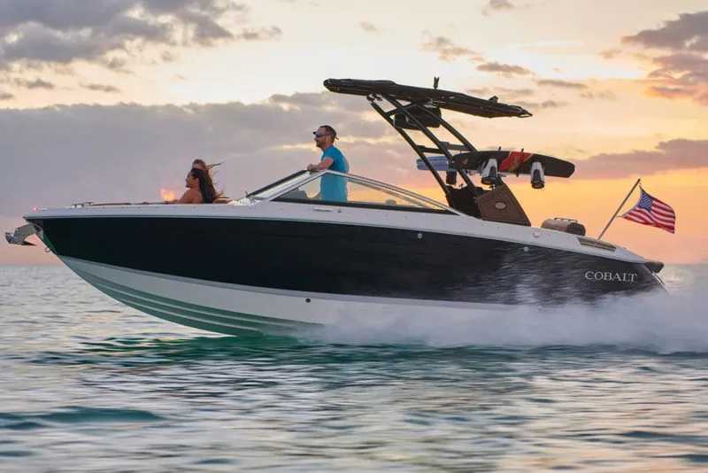 Slide: The Image of Manufacturer Provided Image: 2025 Cobalt R6 boat cruising on water at sunset with American flag. - 10