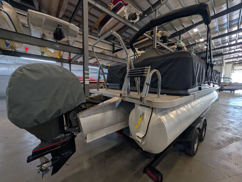 Slide: The Image of 2021 Veranda pontoon boat in storage facility, motor covered. - 9