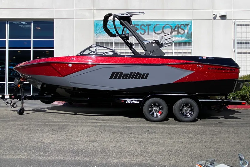 The Image of 2025 Malibu Wakesetter 23 LSV boat in red and gray, parked on a trailer. - 0