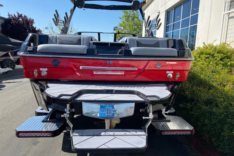 Slide: The Image of 2025 Malibu Wakesetter 23 LSV boat, red exterior, rear view, parked outdoors. - 7