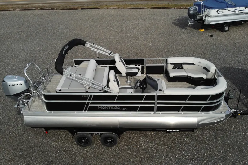 Slide: The Image of 2026 Montego Bay 140HP pontoon boat with Honda motor, parked on a trailer. - 5