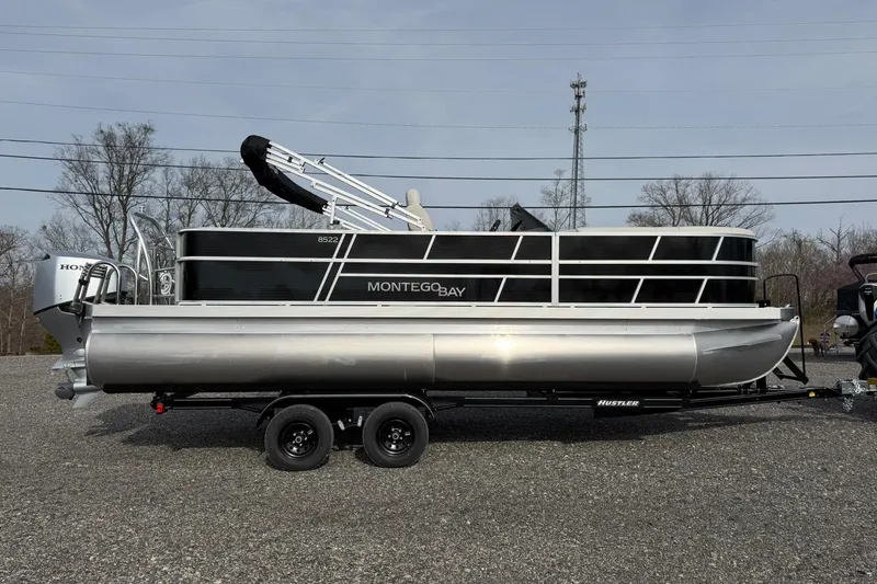 Slide: The Image of 2026 Montego Bay 140HP pontoon boat on trailer, side view, outdoors. - 8