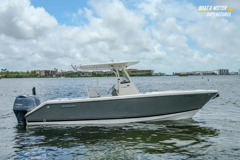The Image of 2016 Pursuit C 260 Center Console boat on calm water under a cloudy sky. - 0