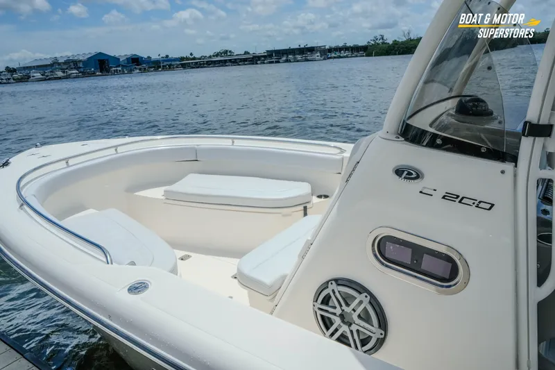 Slide: The Image of 2016 Pursuit C 260 Center Console boat docked by the water on a sunny day. - 2
