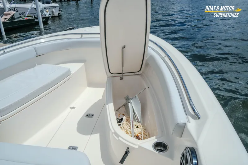 Slide: The Image of 2016 Pursuit C 260 Center Console boat with open storage compartment by the water. - 22