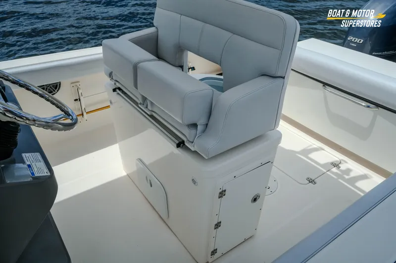 Slide: The Image of 2016 Pursuit C 260 Center Console boat interior with cushioned seating and steering wheel. - 4