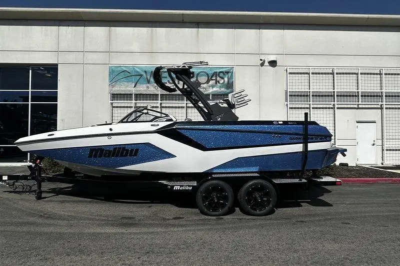 The Image of 2025 Malibu Wakesetter 23 MXZ boat on trailer, parked outside a building. - 0