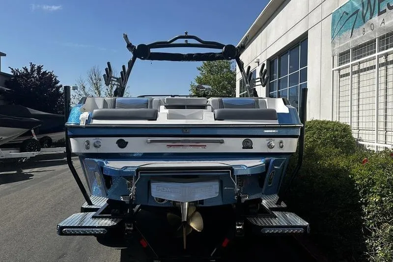 Slide: The Image of 2025 Malibu Wakesetter 23 MXZ boat, rear view, parked outside a dealership. - 5