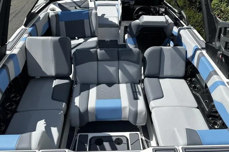 Slide: The Image of 2025 Malibu Wakesetter 23 MXZ interior with blue and gray seating arrangement. - 8