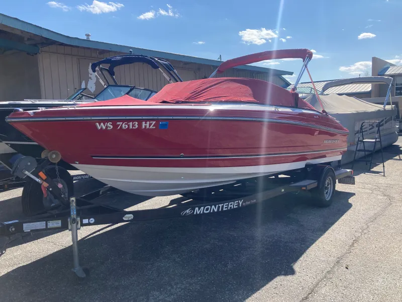 Slide: The Image of Red 2012 Monterey 204FS boat on trailer outdoors. - 19