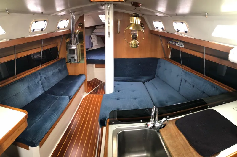 The Image of Interior of a 1992 Catalina 34 sailboat with blue seating and wooden accents. - 1