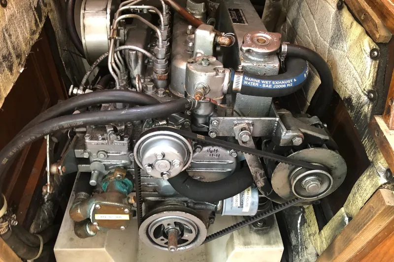 Slide: The Image of Engine compartment of a 1992 Catalina 34 sailboat, showcasing mechanical components and hoses. - 19